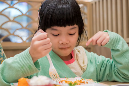 Cute little asian child girl eating foodの写真素材