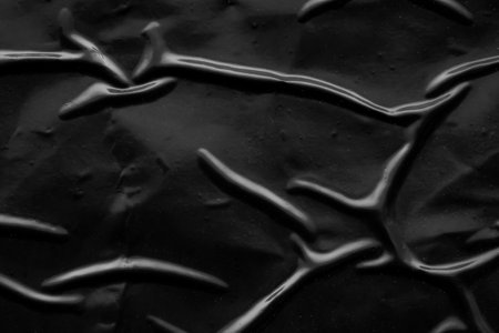 black crumpled and creased plastic poster texture backgroundの写真素材
