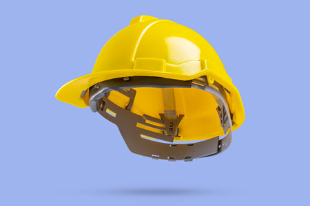 Yellow safety construction helmet on blue backgroundの写真素材