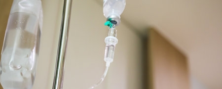 Close up medical intravenous IV drip in hospital background