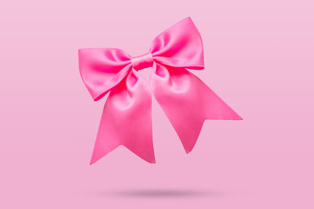 pink gift bow isolated on pink backgroundの写真素材