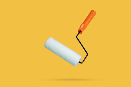 white paint roller floated on yellow background