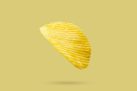 potato chip isolated on yellow backgroundの写真素材
