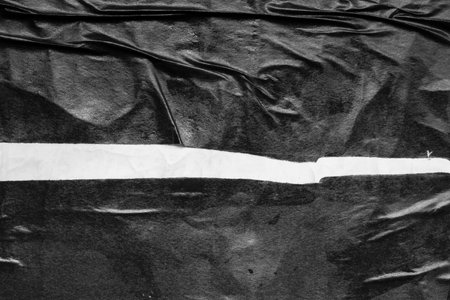 crumpled and creased black and white paper poster grunge texture backgroundの写真素材