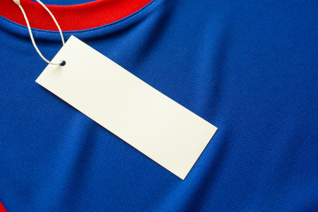 Blank white clothes tag label on blue fabric texture backgroundの写真素材