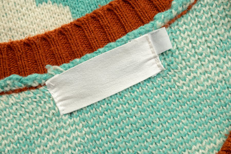White blank laundry care clothes label on blue shirt fabric background