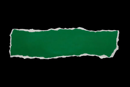 piece of green paper tear isolated on black backgroundの写真素材