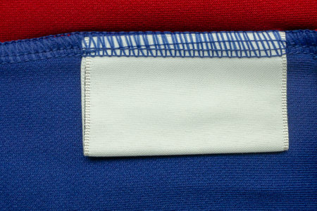 White blank laundry care clothes label on blue shirt fabric backgroundの写真素材