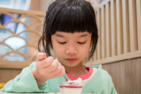 Cute little asian child girl eating foodの写真素材