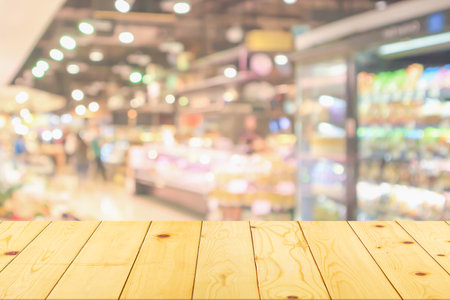 Empty wood table top with supermarket blurred background for product displayの写真素材