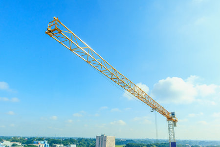 Industrial construction tower crane with blue sky background at building siteの写真素材