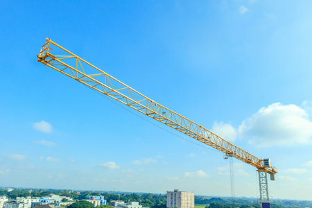 Industrial construction tower crane with blue sky background at building siteの写真素材