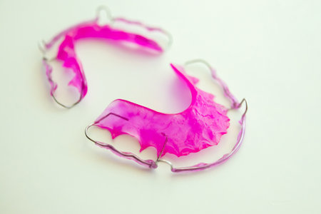 Pink acrylic dental retainer on white backgroundの写真素材