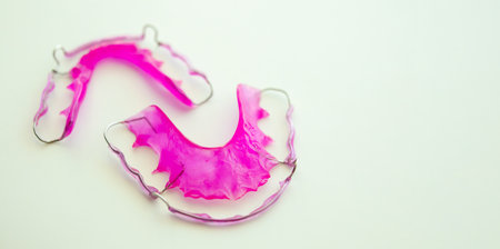 Pink acrylic dental retainer on white backgroundの写真素材