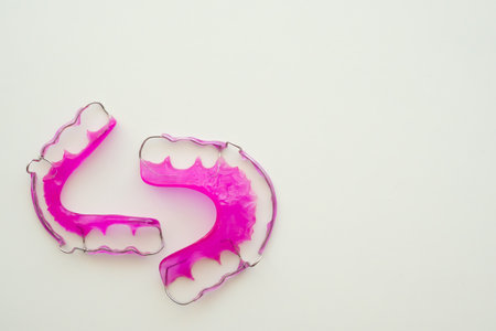 Pink acrylic dental retainer on white backgroundの写真素材