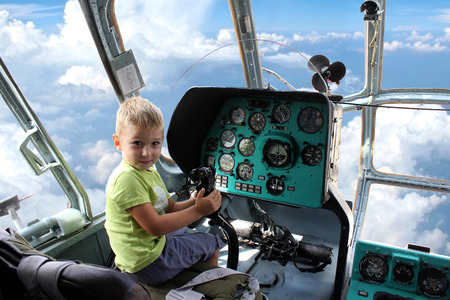 A little boy fly a helicopter. View from helicopter cabin during flight (photomontage)