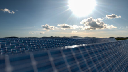 Solar panel background of photovoltaic modules for renewable energy. Clouds and blue sky in mirror....