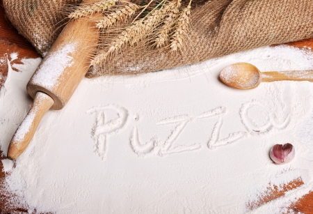 Pizza word written on flour - food backgroundの写真素材