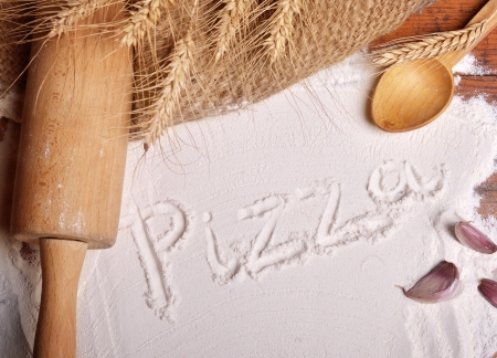 Pizza word written on flour - food backgroundの写真素材