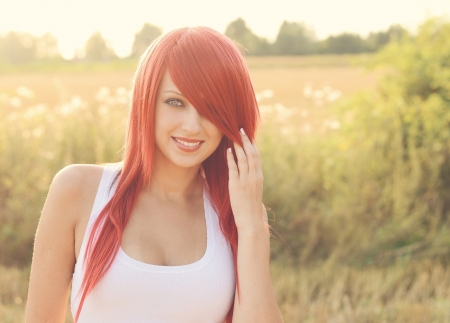 Portrait of beautiful red haired woman on autumn duskの写真素材