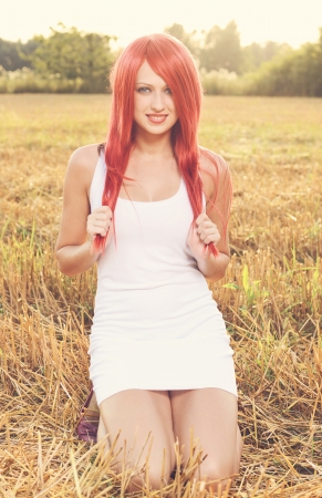 Portrait of beautiful red haired woman on autumn duskの写真素材