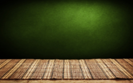 Empty bamboo table and green wall in background. の写真素材