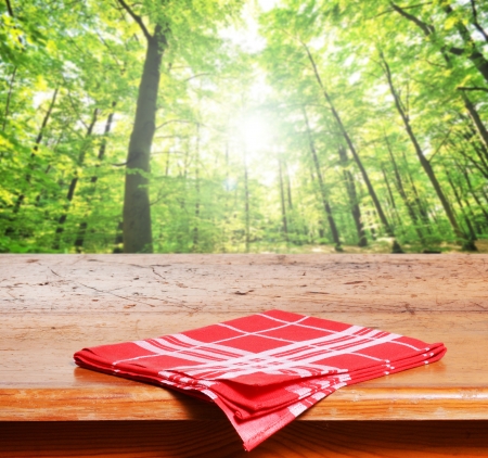 Empty wooden table and green forest in backgroundの写真素材
