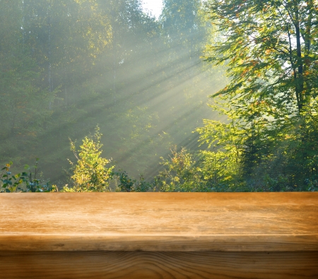 Empty wooden deck table with autumn forest in background. Ready for product display montage.の写真素材