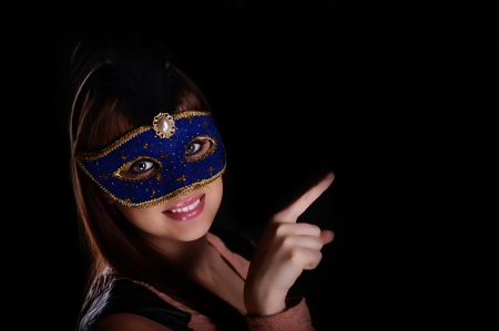 Beautiful caucasian brunette in carnival mask over blue の写真素材