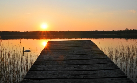 Wooden bridge to the lake under the sunsetの写真素材