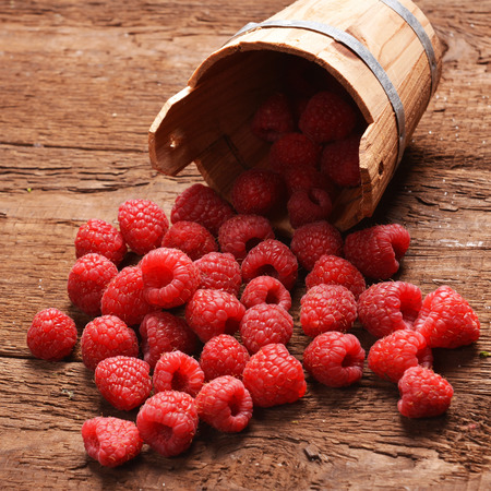 fresh raspberry in a basket on wooden tableの写真素材