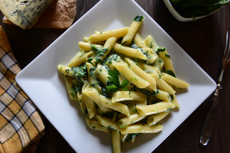 Penne pasta with gorgonzola sauce and spinachの写真素材