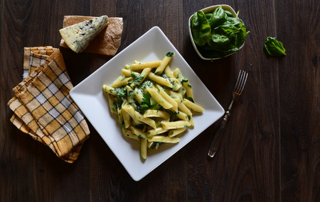 Penne pasta with gorgonzola sauce and spinachの写真素材