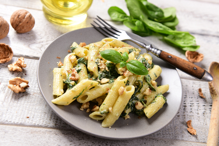 Penne pasta with spinach, gorgonzola cheese and walnutsの写真素材