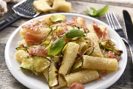 Tasty rigatoni pasta with courgette, prosciutto ham and grana padano cheeseの写真素材