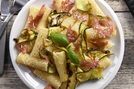 Tasty rigatoni pasta with courgette, prosciutto ham and grana padano cheeseの写真素材