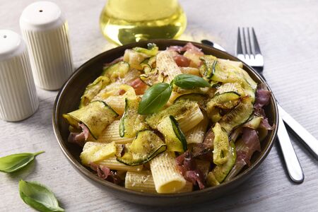Tasty rigatoni pasta with courgette, prosciutto ham and grana padano cheeseの写真素材