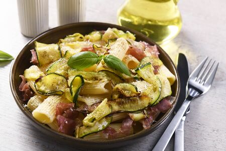 Tasty rigatoni pasta with courgette, prosciutto ham and grana padano cheeseの写真素材