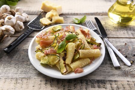 Tasty rigatoni pasta with courgette, prosciutto ham and grana padano cheeseの写真素材