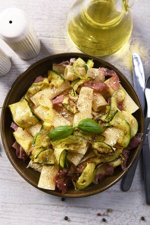 Tasty rigatoni pasta with courgette, prosciutto ham and grana padano cheeseの写真素材