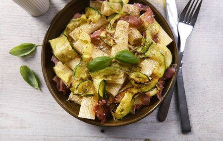 Tasty rigatoni pasta with courgette, prosciutto ham and grana padano cheeseの写真素材