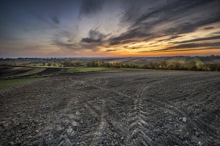 Plowed fields during beautiful sunsetの写真素材