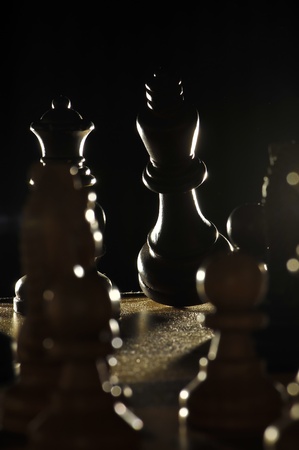 Falling Chess King sourouned by opponent's pawns  lit from the backの写真素材