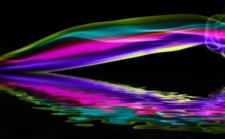 Colorful Smoke flowing horizontally over Black Background above the waterの写真素材