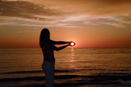 Girl holding the Sun in her hands