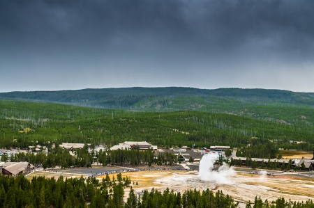 Famous Old Faithful Geyser while erupting taken from the Overlook during stormy weatherの写真素材