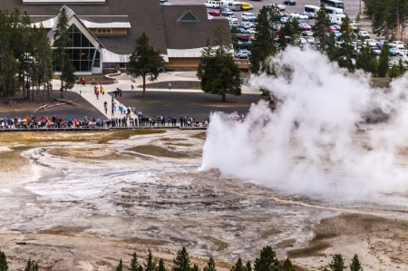 Famous Old Faithful Geyser while erupting taken from the Overlook during stormy weatherの写真素材