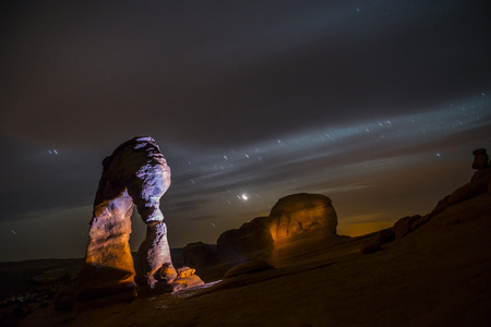Famous Utah Landmark Delicate arch photographed at night with clead skies and shooting starsの写真素材