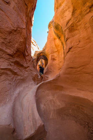 A woman admires the warm light in Peekaboo Gulch in the Escalante Canyons of Grand Staircase Escalante National Monument, Utah.の写真素材
