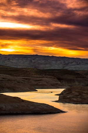 Motorboat cuts the smooth water of Lake Powell at Sunsetの写真素材